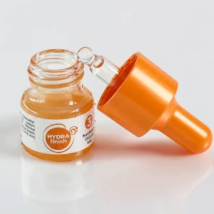 Foto contenitore basso cosmetico con pompetta dosatore di lato aperto color arancio ed effetto 3D flusso